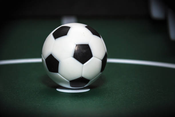istock Soccer table game. Green fieldSoccer table game. Green field and plastic ball on it. with blue and white plastic footballers 897302652