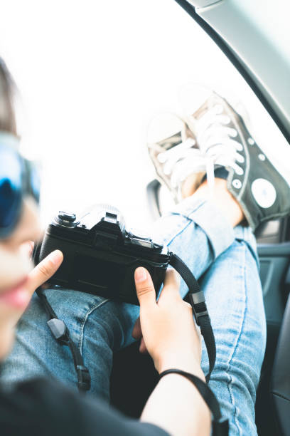 istock cheerful woman in car taking photos with camera 897311952