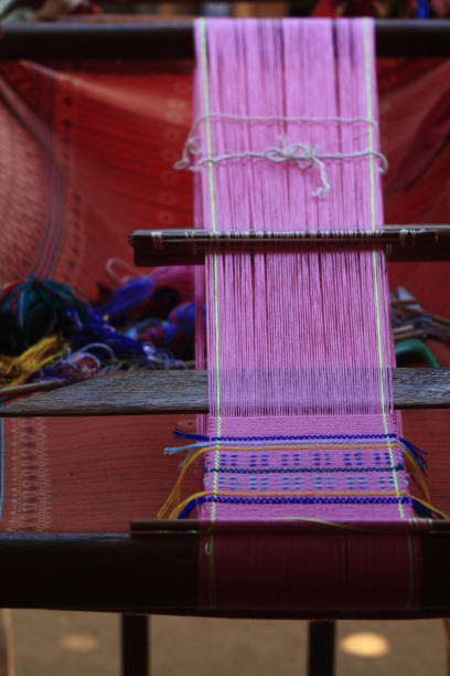 istock swathe of pink thread on a handmade weaving machine 897311998