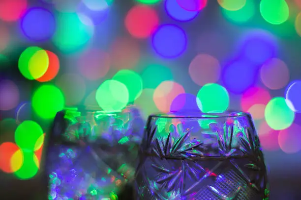 Photo of two glasses of champagne against bokeh lights background