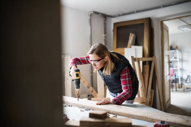 istock Young woman worker in the carpenter workroom. 897332772
