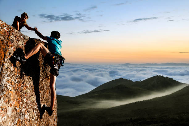 hikers ayudar - pico montaña fotos fotografías e imágenes de stock