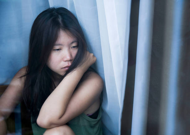 若い悲しみと落ち込んでアジア中国女性思慮深い痛みと悲しみと生活問題の概念のうつ病に苦しんでいるウィンドウ ガラスを通して見る - broken window glass women ストックフォトと画像