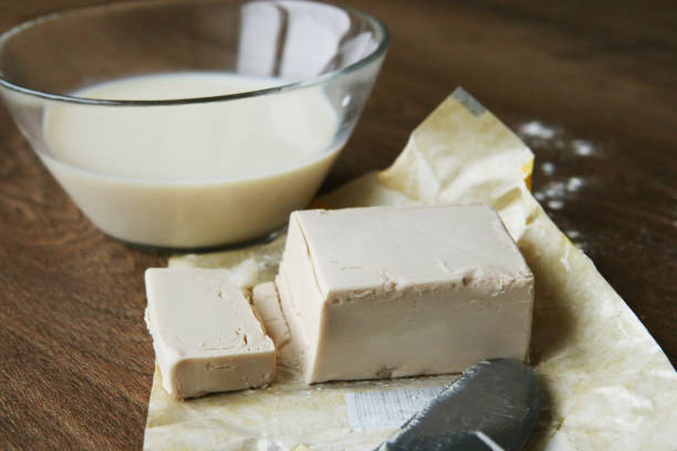 istock Fresh yeast block and milk for baking. 897353162