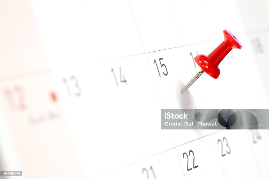 Embroidered red pins on a calendar on the 15th with selective focus Calendar Stock Photo