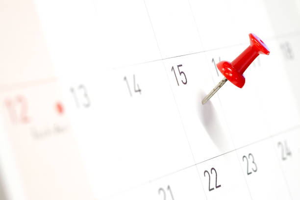 Embroidered red pins on a calendar on the 15th with selective focus Embroidered red pins on a calendar on the 15th with selective focus april photos stock pictures, royalty-free photos & images