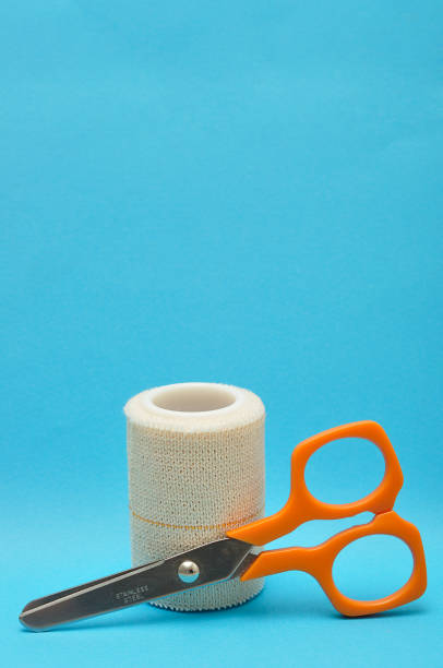 istock A roll of plaster with a scissor isolated on a blue background 897357214