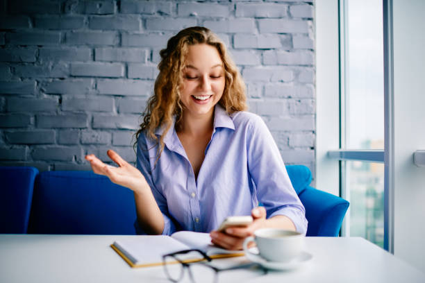 istock Emotional happy hipster girl received message about benefits in roaming from mobile operator during studying at book.Positive young woman reading good news on mobile smartphone sitting in cafe 897366692