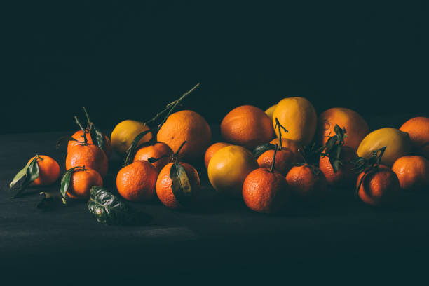 close up view of ripe mandarins and lemons on wooden tabletop