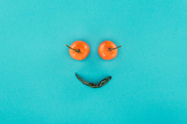 istock top view of tangerines and leaf arranged into smiling face isolated on blue 897370218