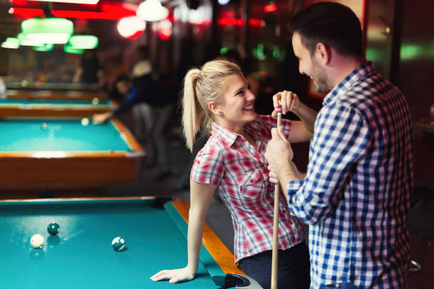 istock Young couple enjoying playing snooker on date 897375202