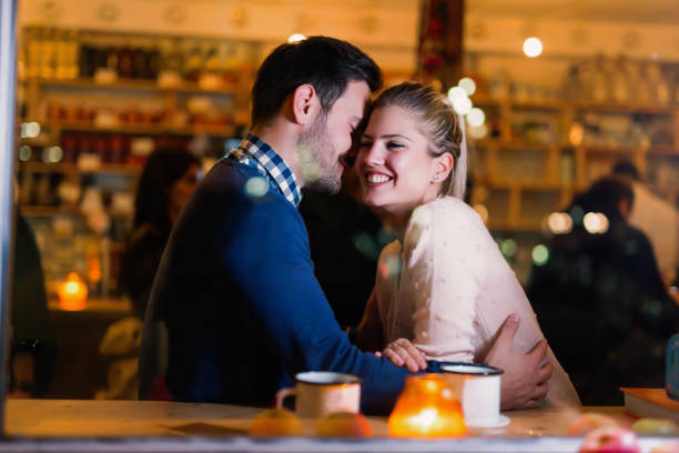 istock Young attractive couple on date in bar 897375720
