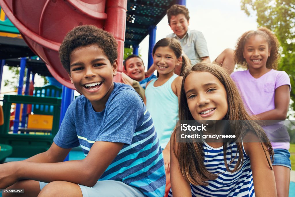 Playground and friends, fun guaranteed Shot of a group of young friends hanging out together at a playground Child Stock Photo