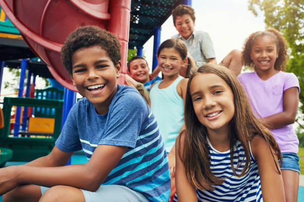 Playground and friends, fun guaranteed Shot of a group of young friends hanging out together at a playground play equipment stock pictures, royalty-free photos & images