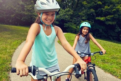 Shot of two young girls out for a bicycle ride in the park