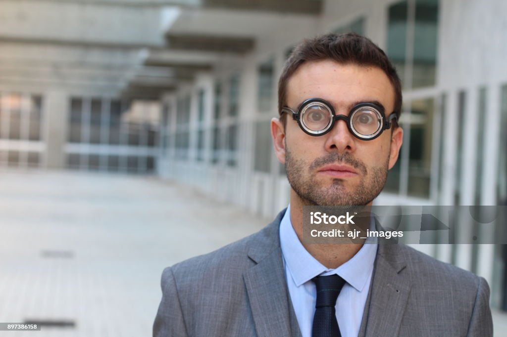 Foolish geek looking stunned in the office Foolish geek looking stunned in the office. Eyeglasses Stock Photo