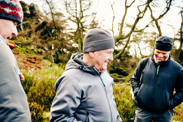 istock Smiling senior man hiking on mountain trail with friends 897410370