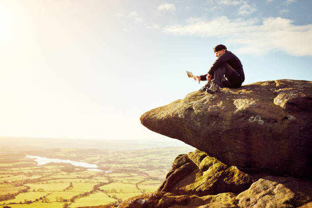 istock Male hiker sitting on top of a mountain with a map 897410426