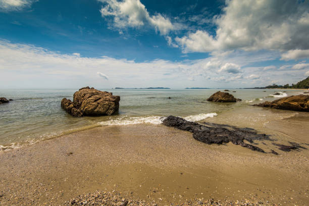 istock Rocks on tropical beach showing volcanic origins. 897414430