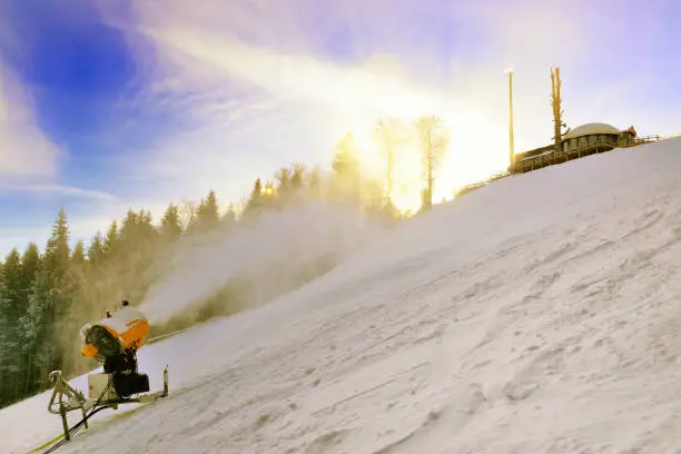 Photo of Snow cannon prepares ski slope high in the mountains