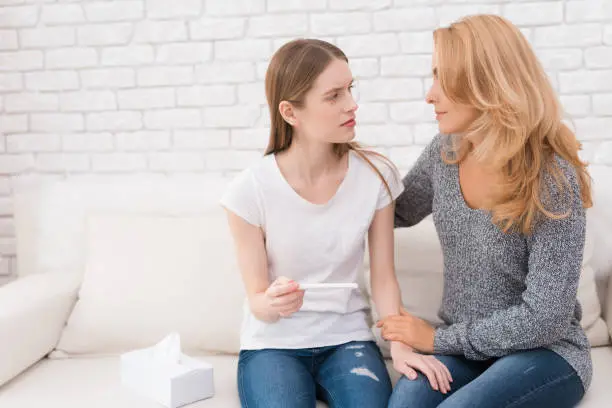 Photo of Mom comforts her daughter, who learned that she was pregnant.