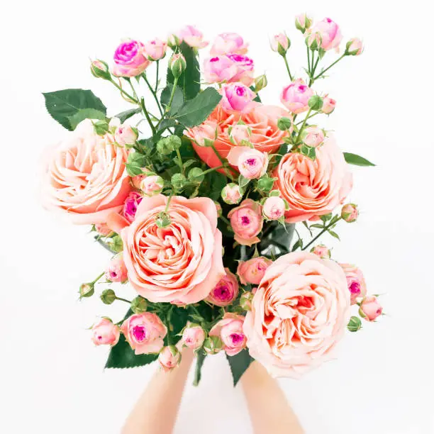 Photo of Beautiful bouquet with pink roses in hands on white background. Flat lay, top view. Valentines day composition