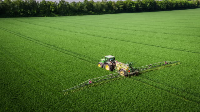 Aerial: Tractor Applying Liquid Nitrogen Fertilizer to Corn Field