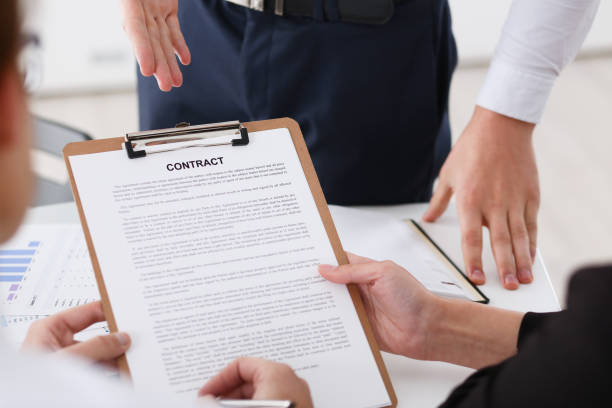 istock Male arm in shirt offer contract form on clipboard 897451920