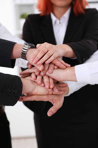 istock Group of people in suits crossed hands pile 897451940