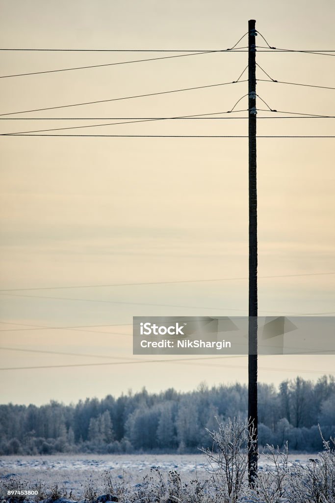 post pole pillar transmission facilities in winter sunset Agricultural Field Stock Photo