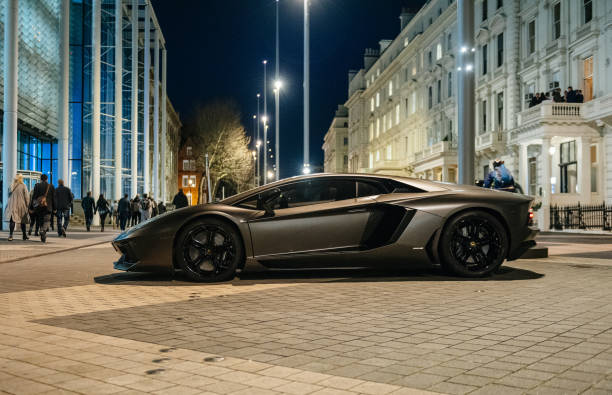 Lamborghini Aventador luxury sport carbon car parked on Kensignton Street in London London: Rich businessmen party on the balcony with unique luxury super-car parked on Exhibition Rd, Kensington London. Lamborghini Aventador is a mid-engine sports car status car photos stock pictures, royalty-free photos & images