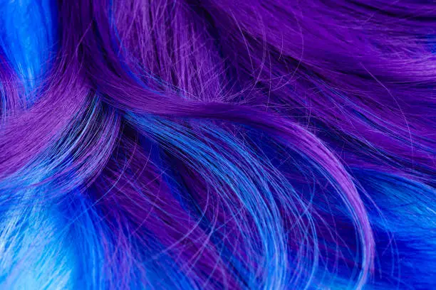 Photo of Closeup of colorful hair in purple and turquoise blue colors