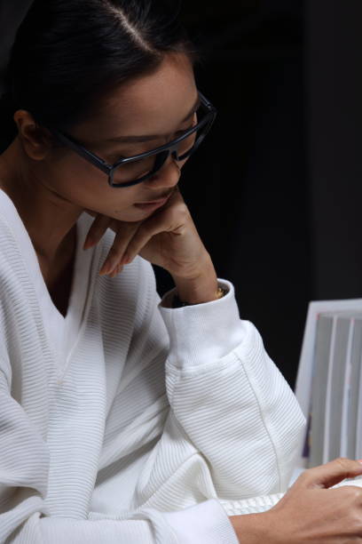 istock Girl in white shirt reading many textbooks on table with many high stacking 897487032