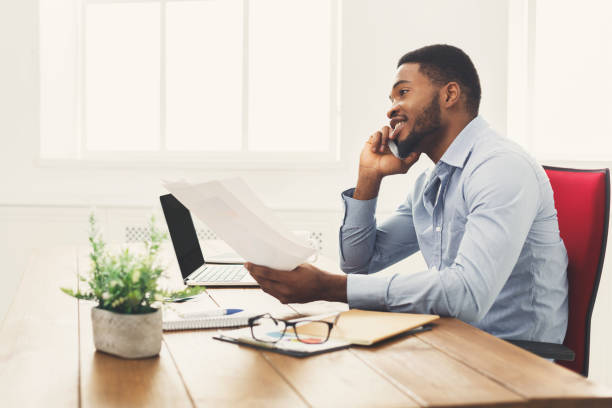 istock Young black businessman talking on mobile phone 897488106