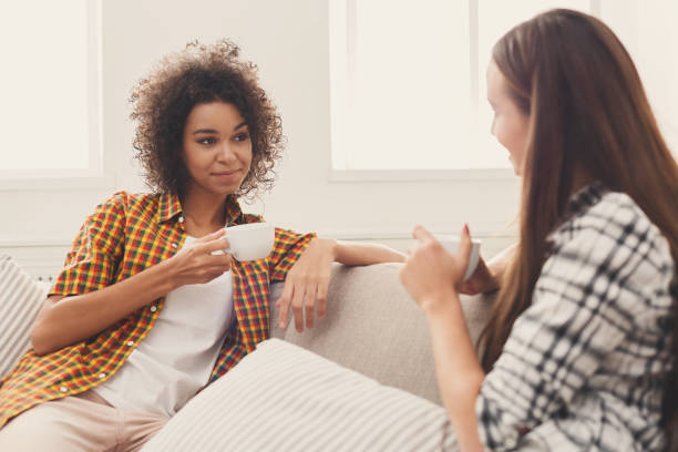 istock Two young female friends with coffee conversing 897498892