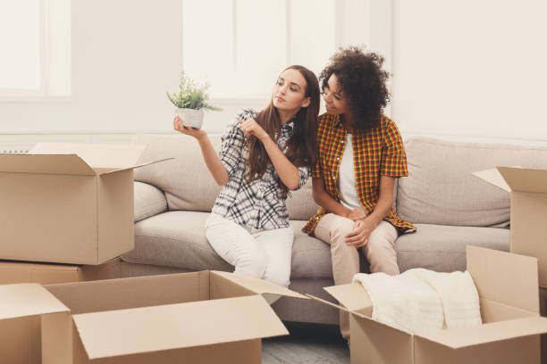 istock Two young women unpacking moving boxes 897504164