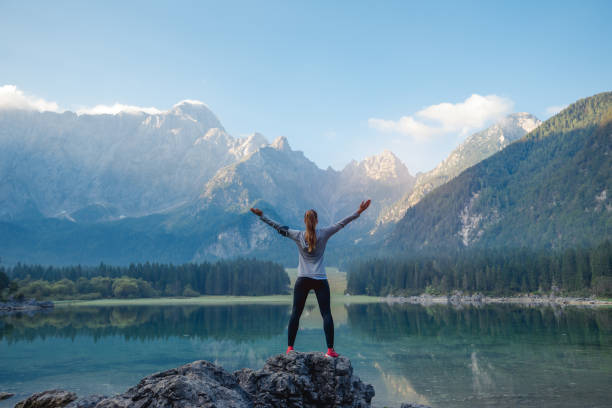 Success Woman wearing sport clothing staning on the rock. Success, freedom concept. arms outstretched photos stock pictures, royalty-free photos & images