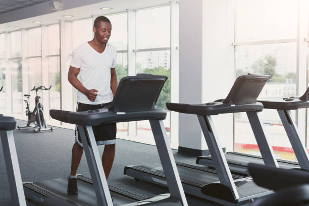 istock Young man in gym run on treadmill 897515490