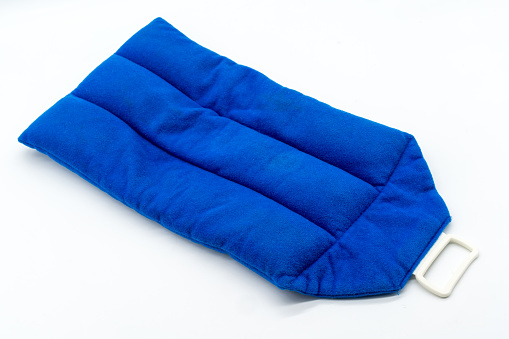 Blue microwave heating pad isolated on white background. Cold and hot wrap for shoulder,  neck, back, and body pain relief therapy.