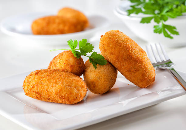 Traditional Spanish croquetas Homemade gourmet croquettes on a white plate with fork. fried potato stock pictures, royalty-free photos & images