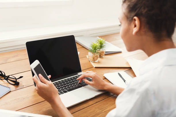 istock Back view of young woman using laptop with blank screen 897525254