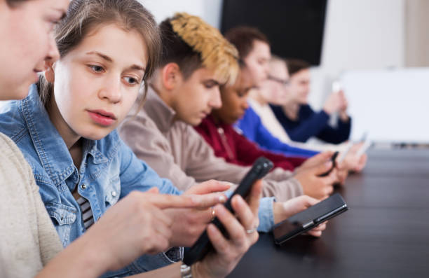 istock Male and female students playing with smartphones 897541376