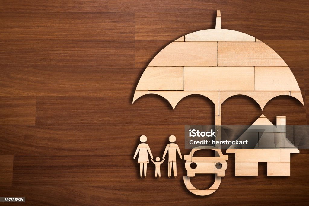 Wooden silhouette of family under umbrella - Concept of Insurance Insurance Stock Photo