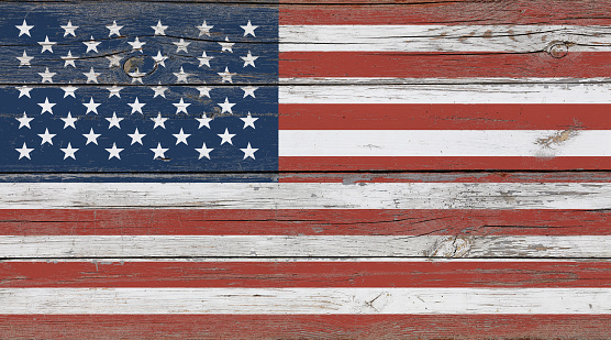 Old vintage American US flag over white wood