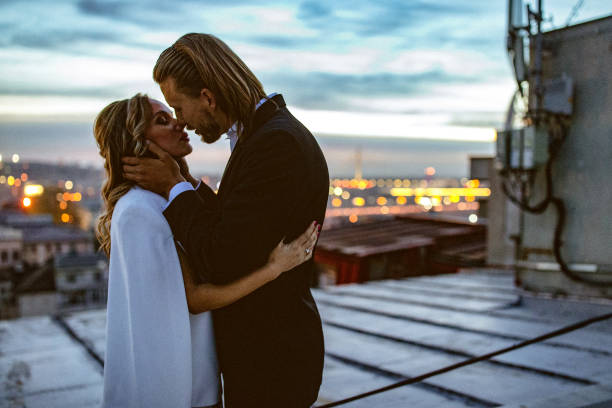 istock Affectionate bride and groom, embraces and kisses on the rooftop at sunset. 897557866