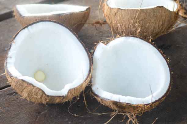 istock Ripe half cut coconut on a wooden background. 897560908