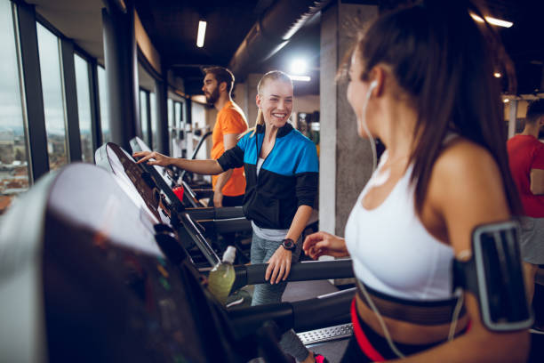 istock Young women resting from exercising on treadmills and communicating. 897561444