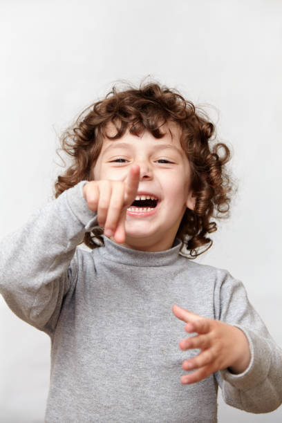 istock Laughing little girl pointing finger at camera 897564760