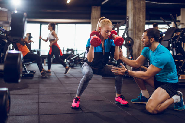 쪼 그리고 앉아서 위치에 아령으로 운동 하는 여자 - dumbbell women body building exercises flexing muscles 뉴스 사진 이미지