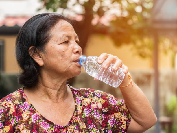 istock The elderly asian woman drinking water from bottle 897572832